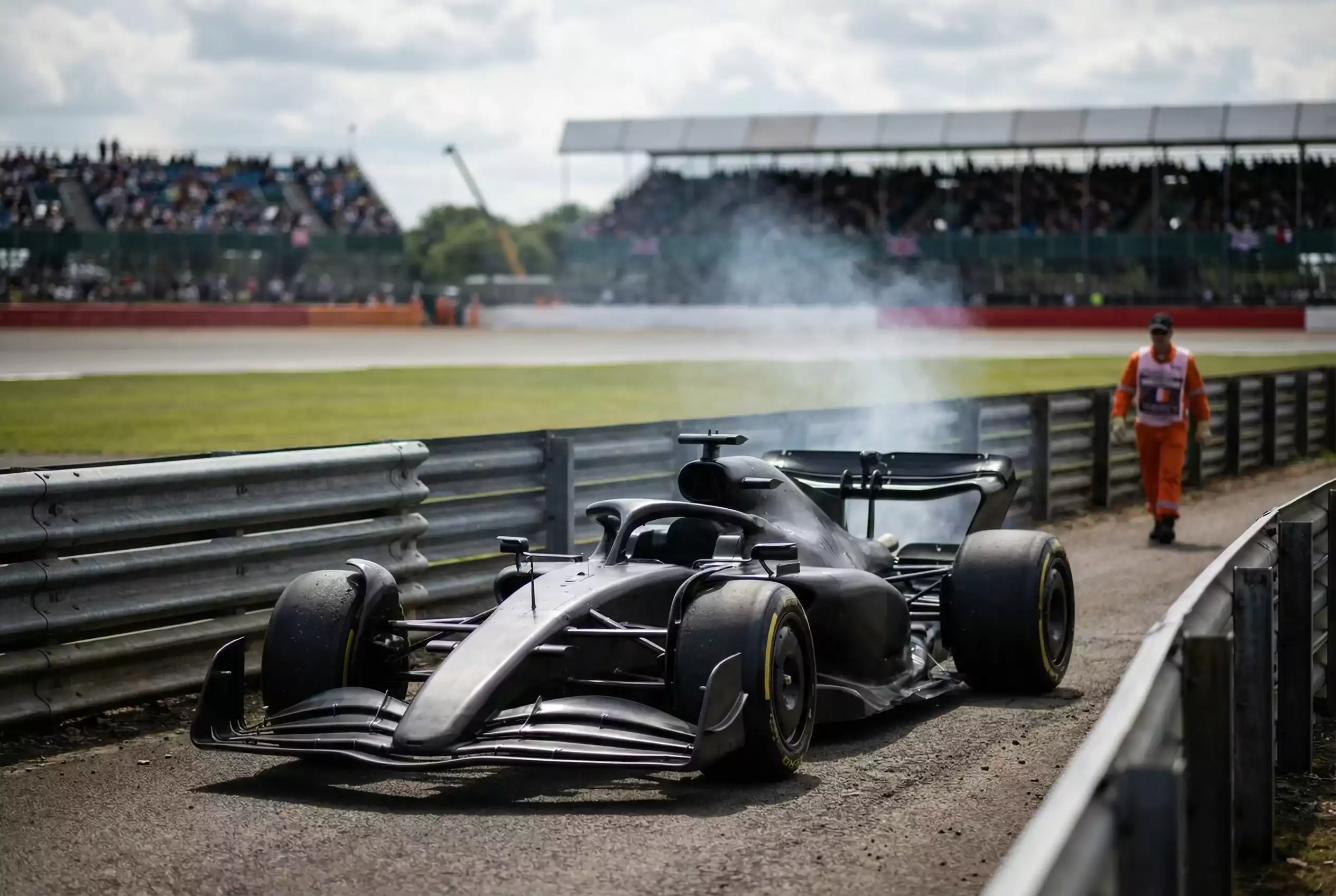 Formel-1-Rennwagen mit Rauch am Streckenrand nach technischem Ausfall