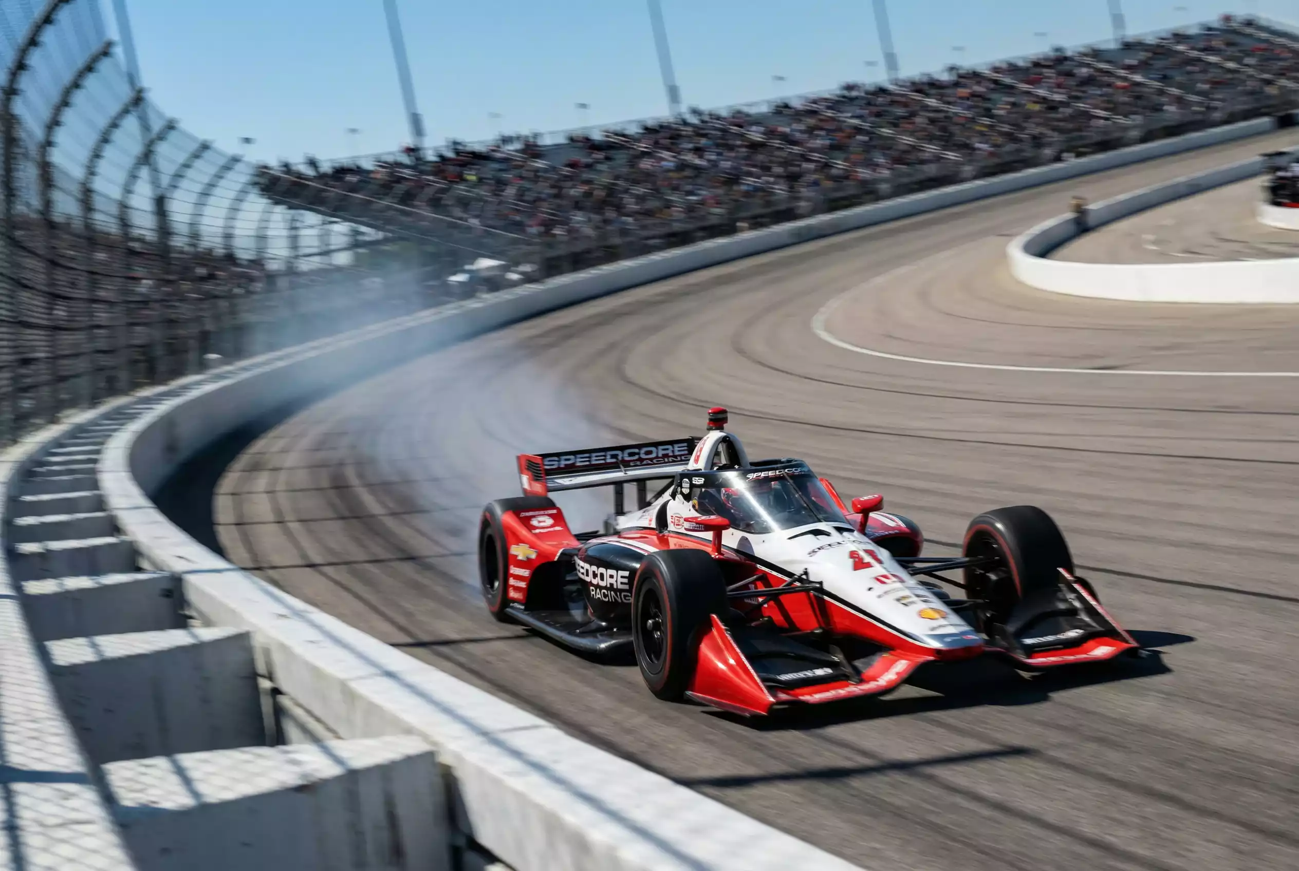 IndyCar-Rennwagen auf einem Oval-Kurs bei Höchstgeschwindigkeit