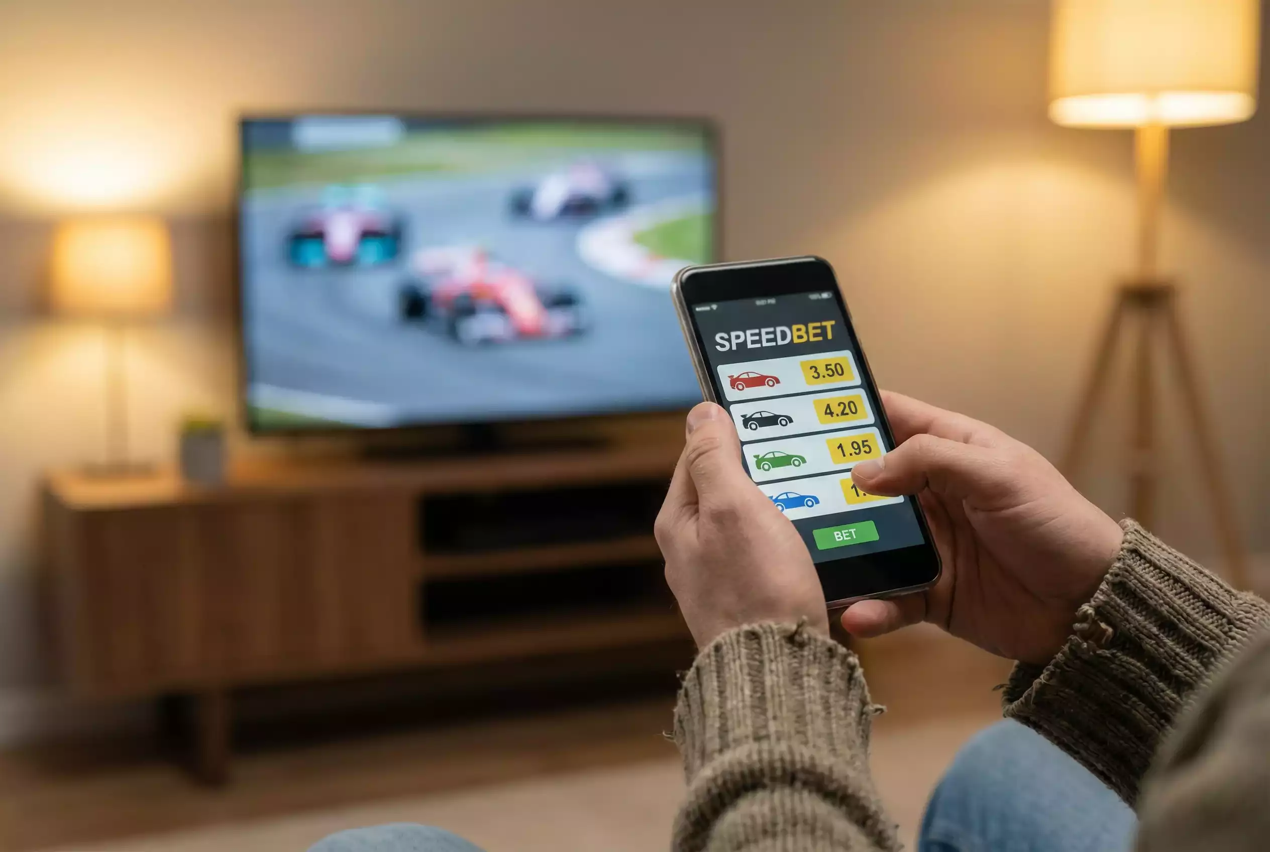 Person betrachtet Motorsport-Wettquoten auf einem Smartphone während eines Rennens