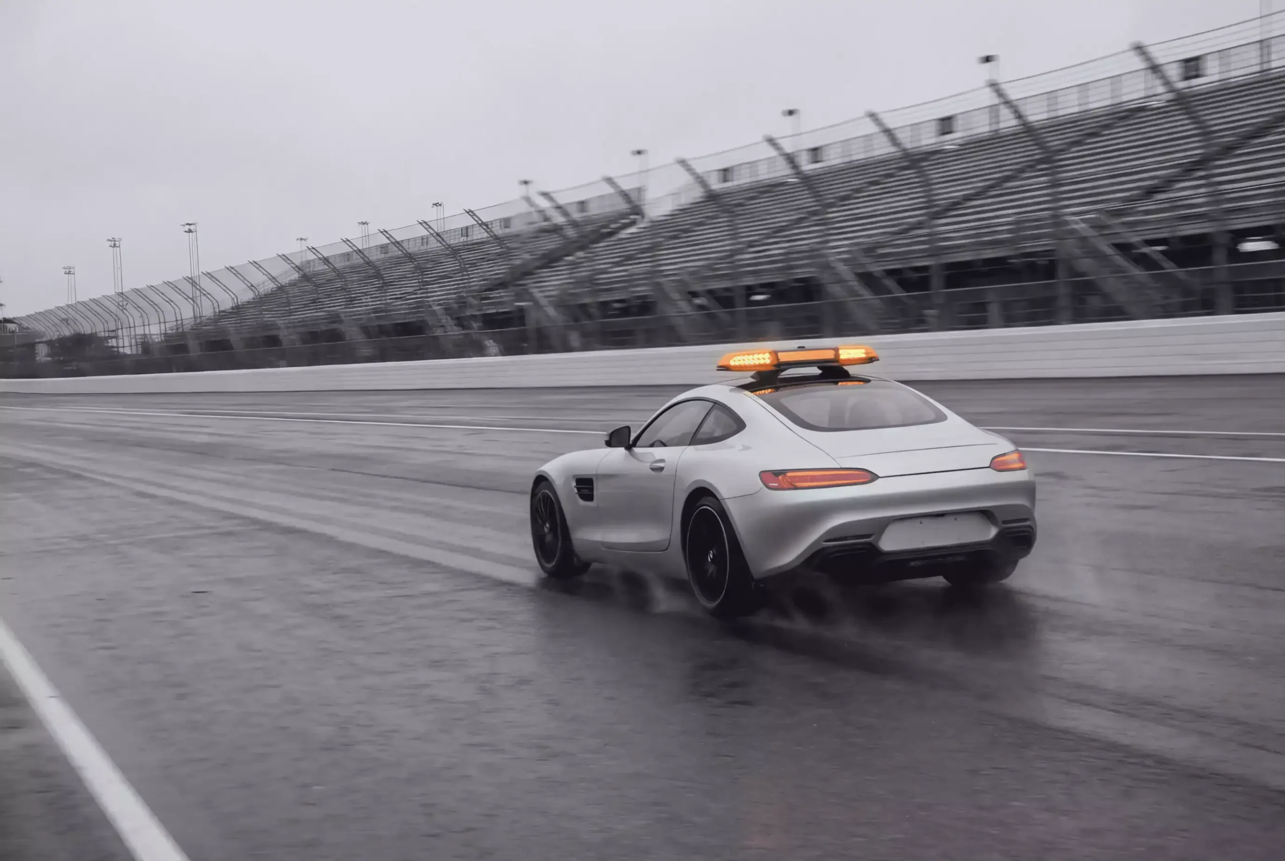 Safety Car mit Blinklichtern auf einer Formel-1-Rennstrecke vor dem Fahrerfeld